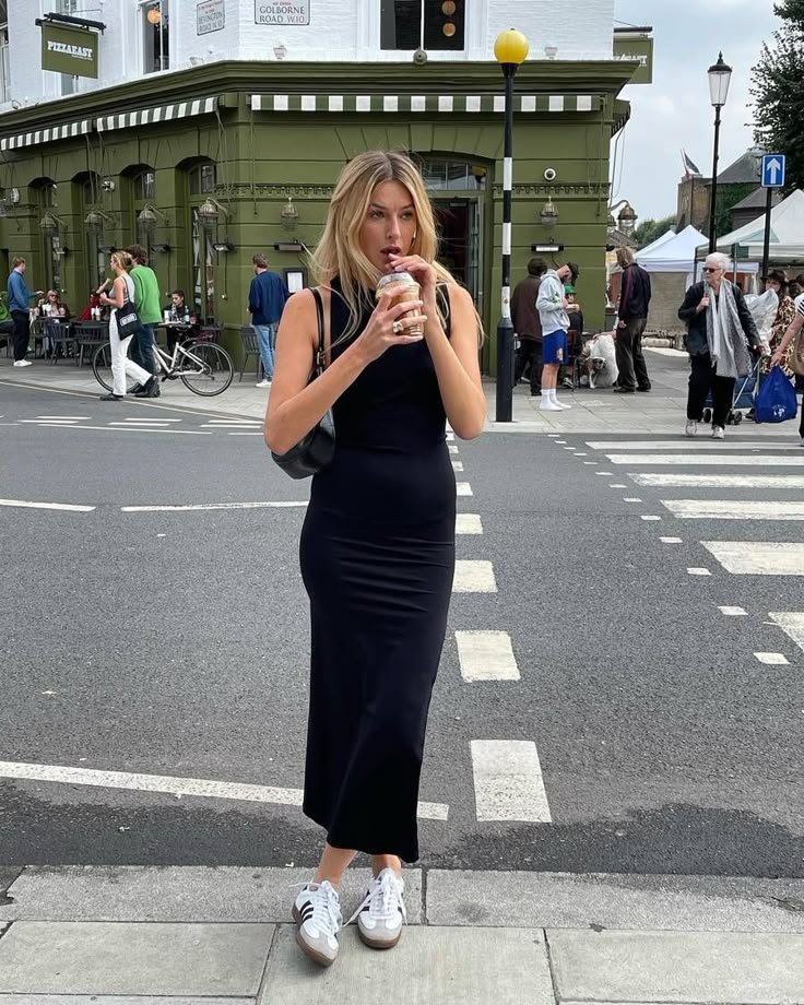 woman wearing black dress and sneakers outfit