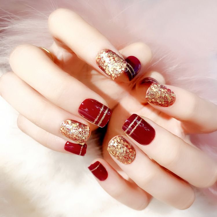 short splatter nails design with red and gold nails polish