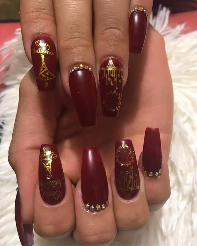 Long burgundy nails with gold rhinestone and studs design ideas