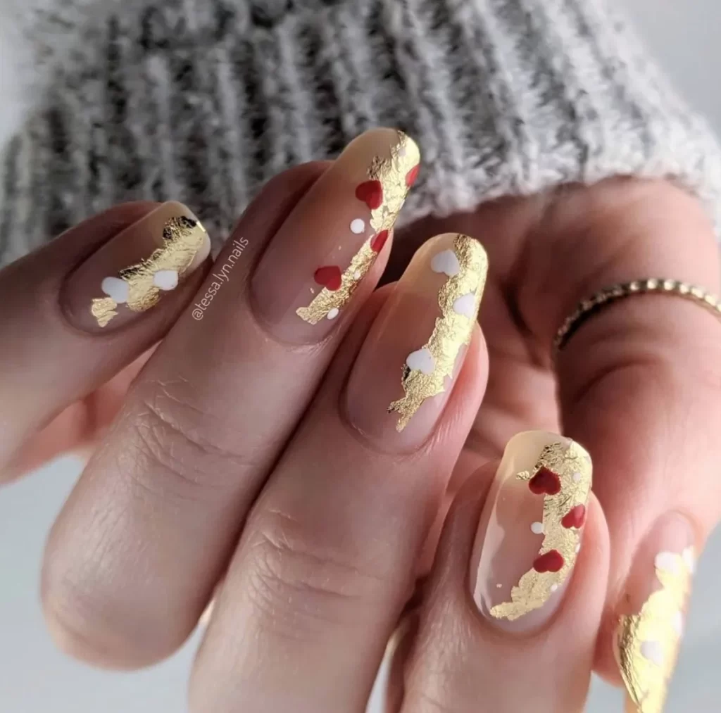 gold and red nails with red heart design 