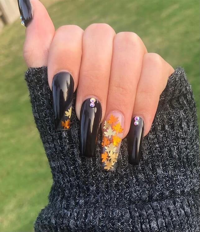 Black coffin leaf nails with rhinestones fall leaf designs. 