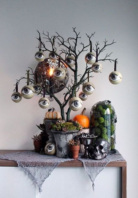 Black Halloween tree with lots of eyeballs with pumpkins and spiders under it