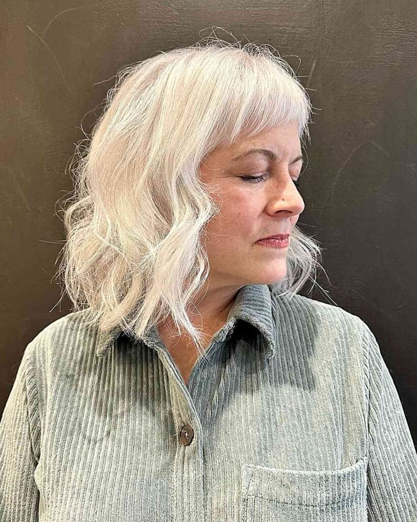 woman with white thin hair with short curved bang over 50