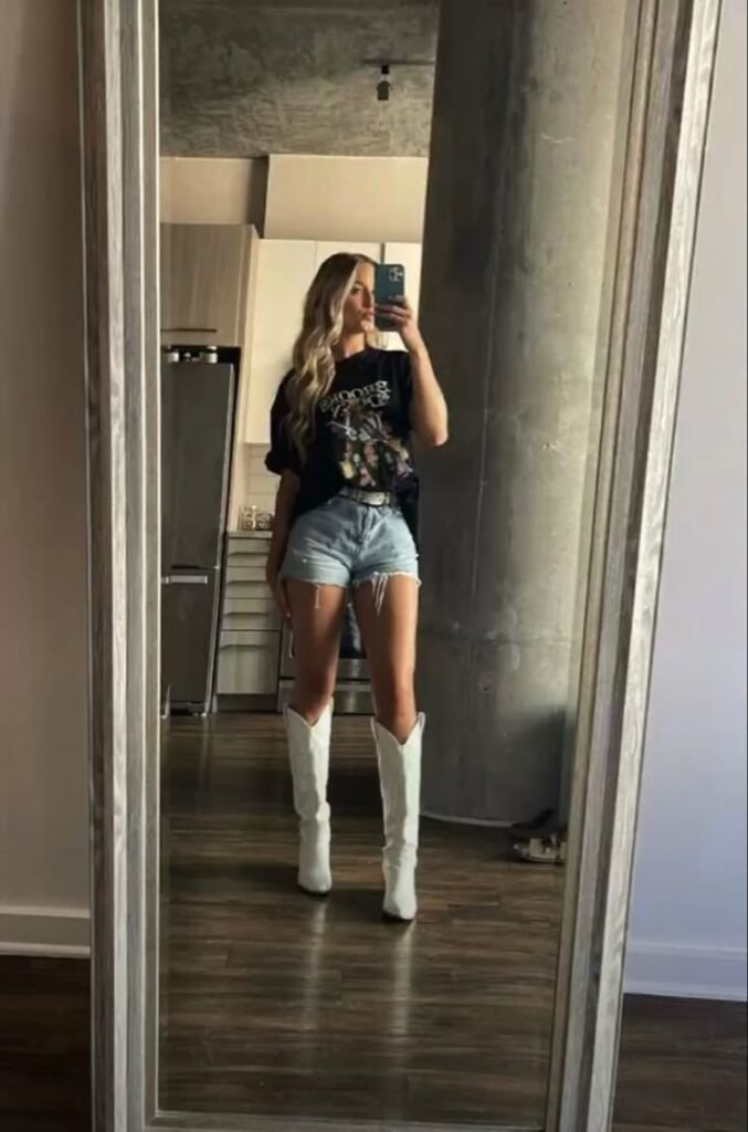 Nashville outfit idea for woman. This outfit features graphic tee shirt, short denim and white boots.