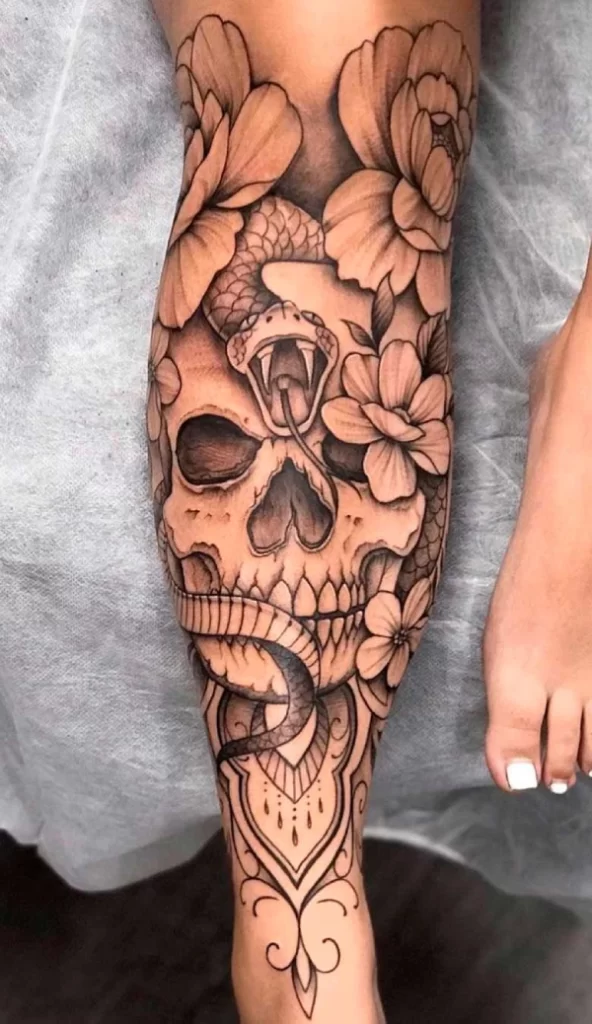 skull tattoo with flowers on legs