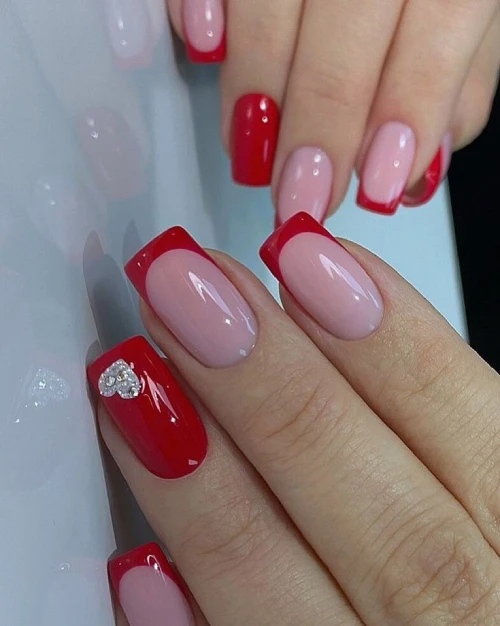 Short red french tip nails with silver design