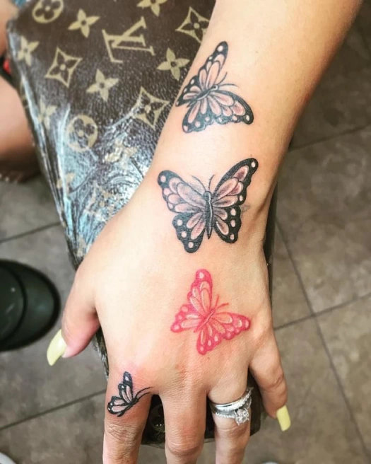 red butterfly hand tattoo