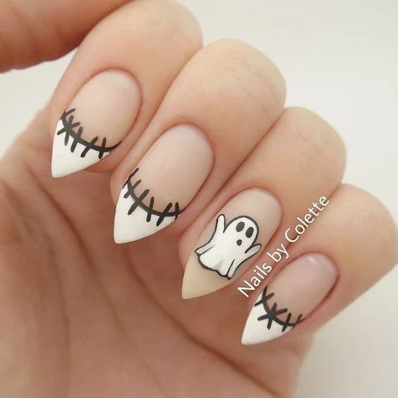 Black and white spooky French tip nail art with ghost design.