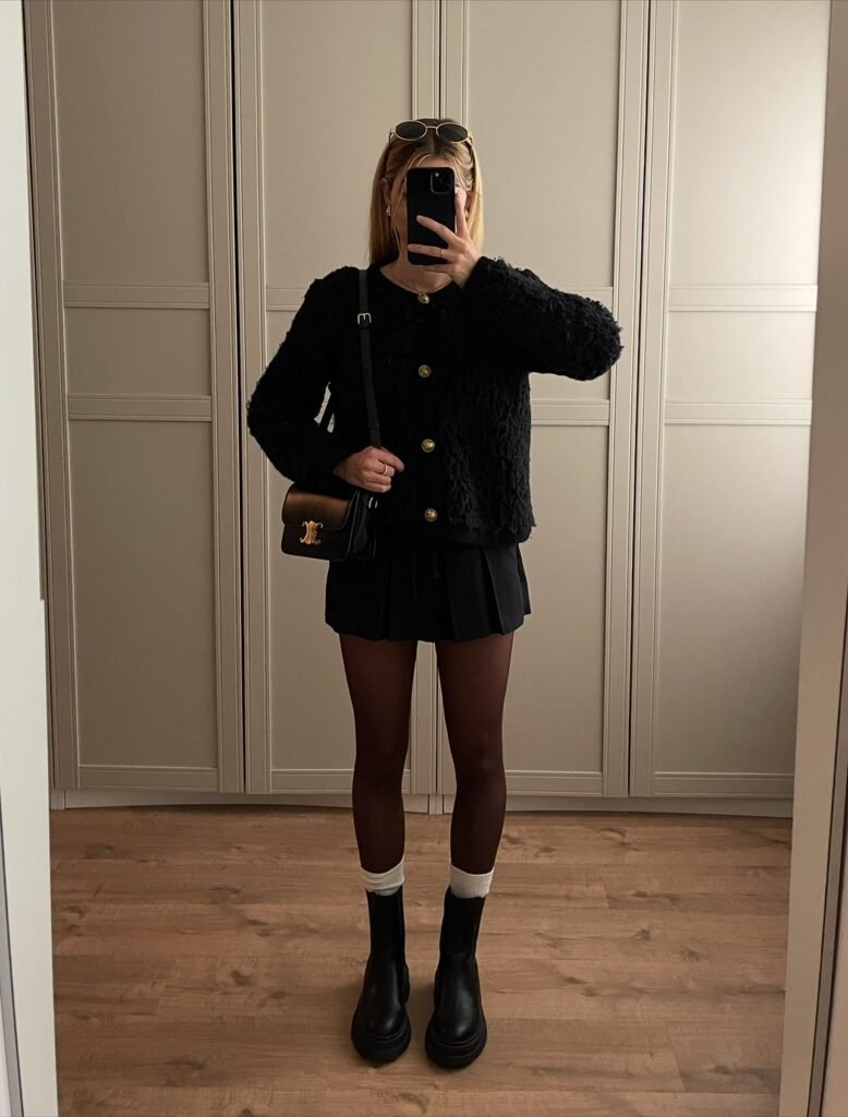 all black pleated ksirt and cardigan sweater outfit.