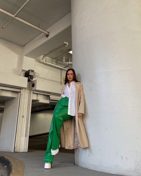 Trench coat in beige, white button down shirt and leather green pants