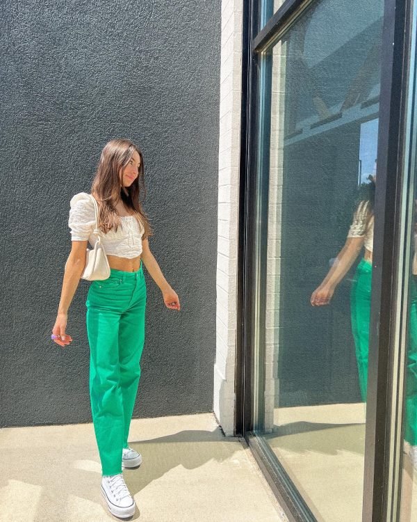 Bright green denim pants and white blouse