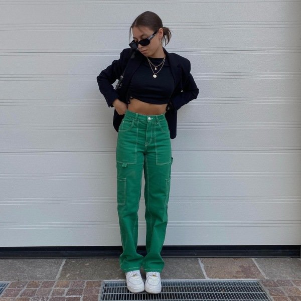 Woman wearing black blouse, blazer and green cargo pants
