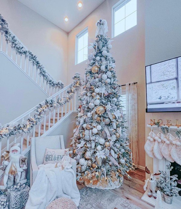 Flocked tree with large gold ornament and flowers