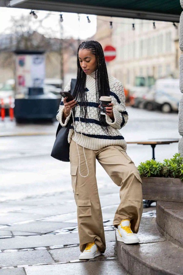 Casual winter style with cargo pants, a cream oversized sweater, and chunky white sneakers