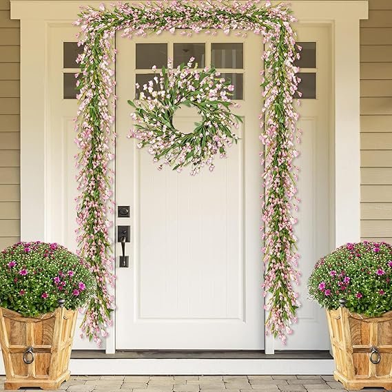 A floral garland with white and pink flowers wrapped around a porch railing.