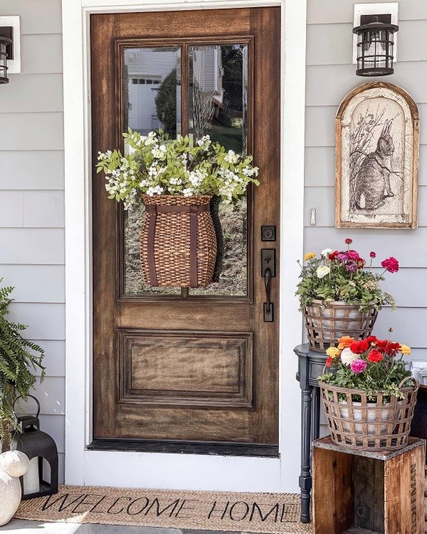 A collection of potted plants in various sizes lining the edge of a porch