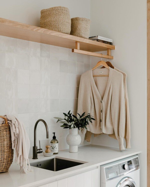 How to decorate you laundry room using shelves. Wall-mounted shelves above the washer and dryer hold baskets and laundry essentials. They help maximize vertical space and keep the area neat.