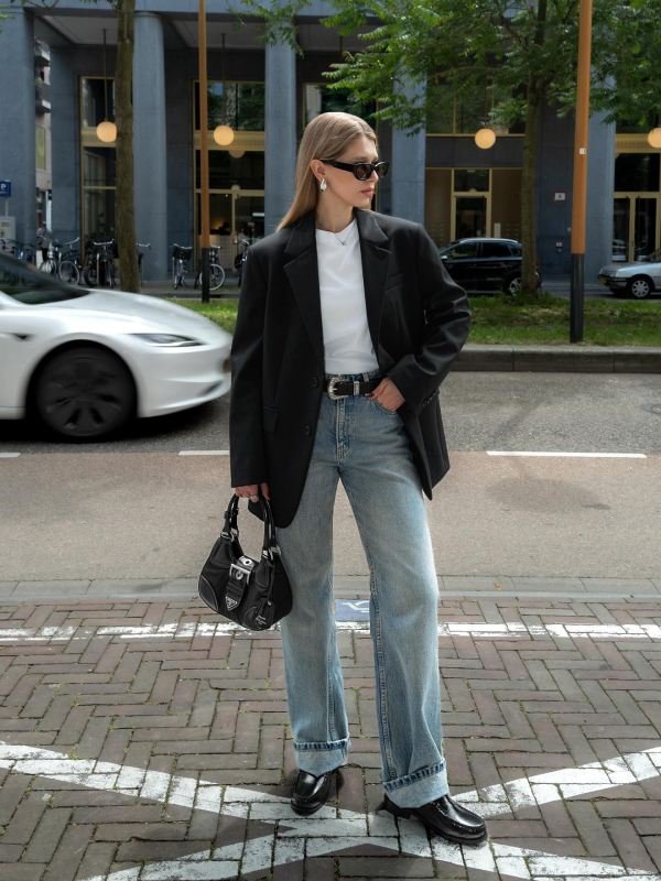 Oversized blazer and blue jeans, with black dress shoes and sunglasses.