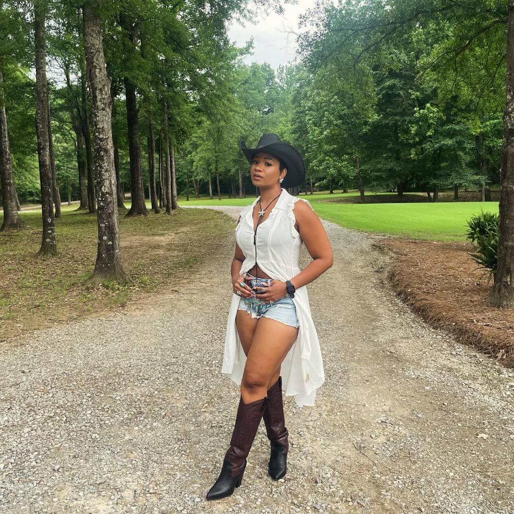 Cowboy Outfit Black Woman - long white button down shirt with brown boots, denim short and black hat. 