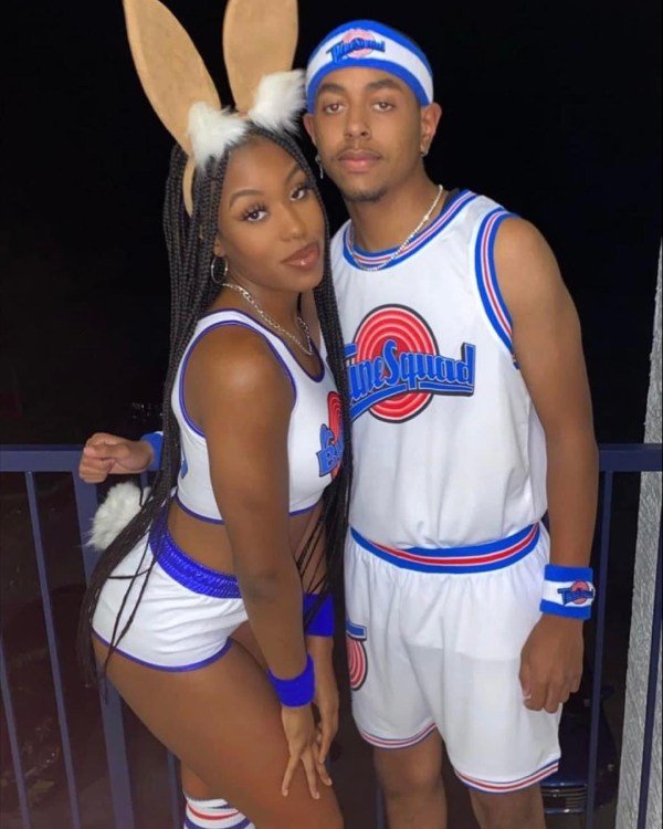 A sporty and animated Halloween costume with a Black couple dressed as Bugs and Lola Bunny. They wear jerseys, bunny ears, and sneakers for a playful, athletic vibe.