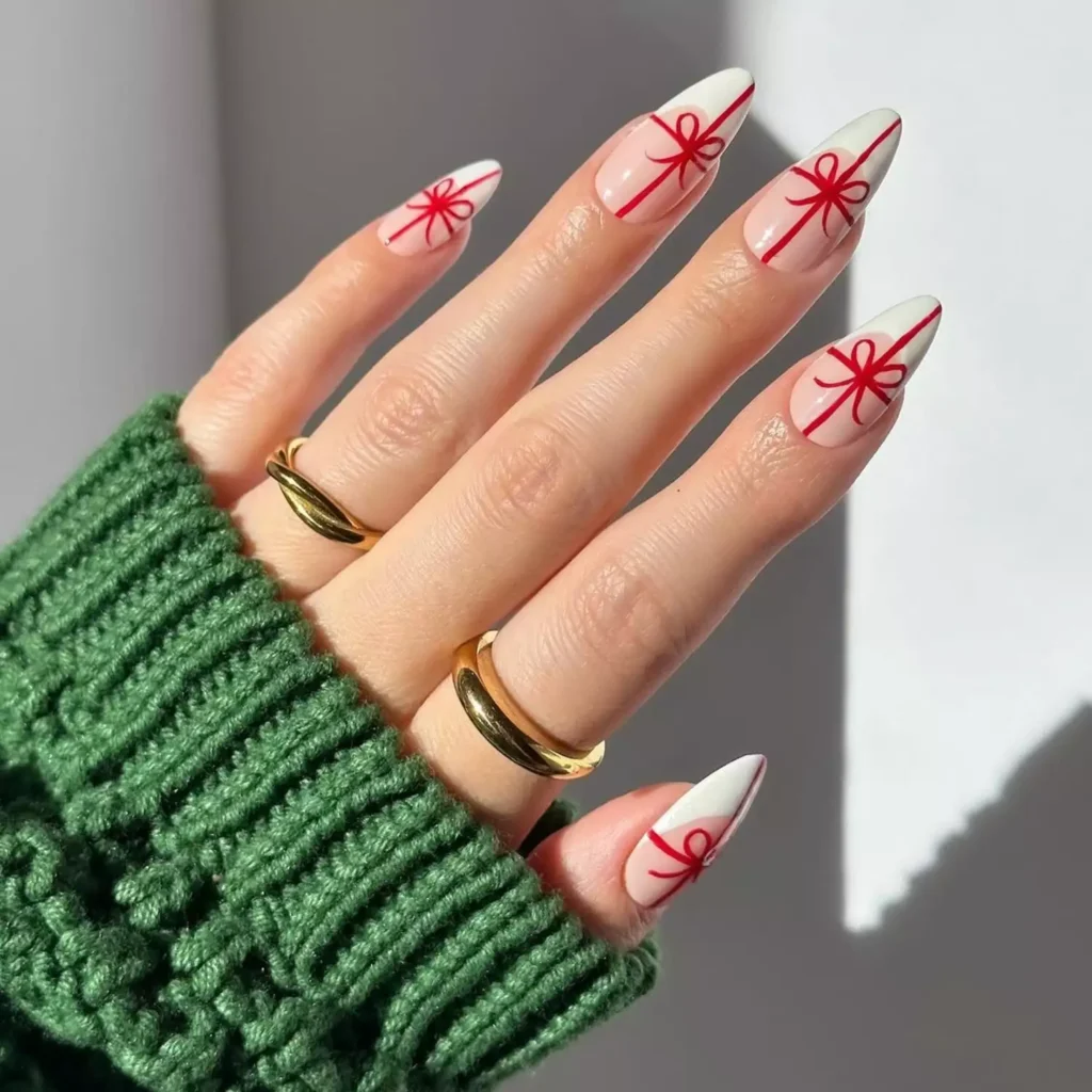 Cute nails with french tip and red bow on the tips. Stunning amnicure for those who love almond hsape nails with classic design.