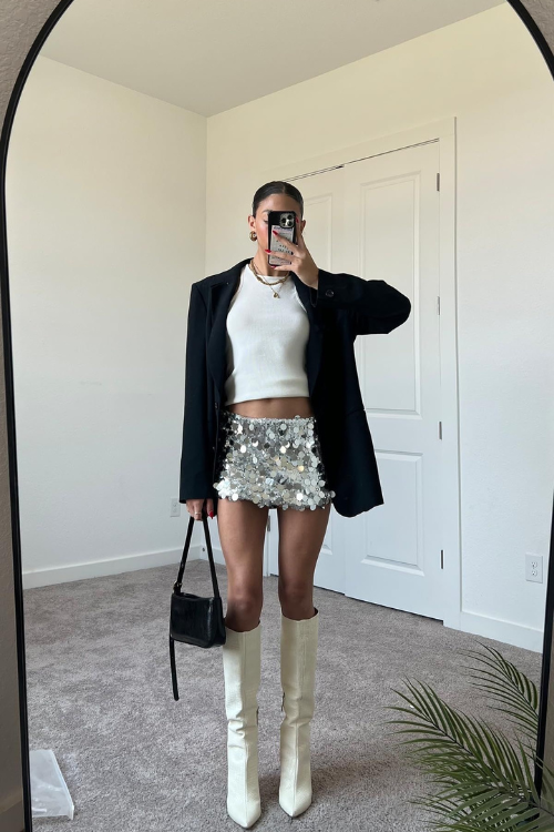 Large silver sequin on mini skirt and white boots.
