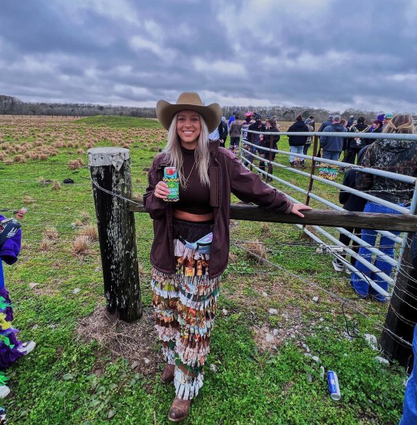Edgy Mardi Gras outfit with fringe cowboy pants and an oversized leather jacket.