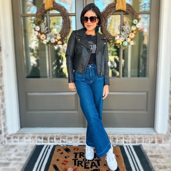 Black straight-leg jeans, silk camisole, and leather moto jacket concert outfit for women over 40