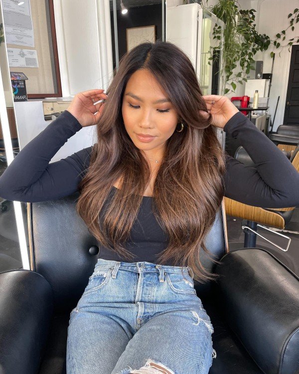 Brunette hair with root smudge and highlights blending grey regrowth