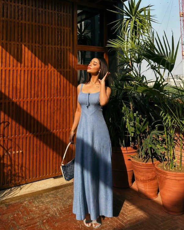Woman wearing a lightweight blue sundress styled with sandals for a casual summer party