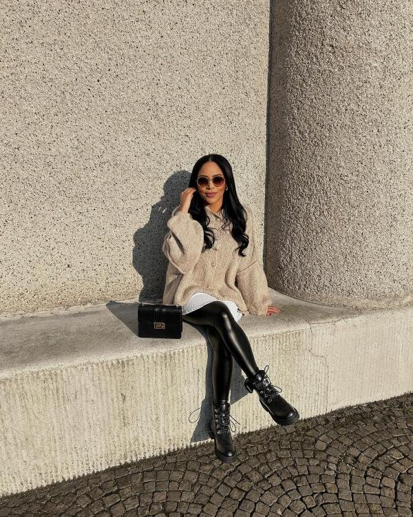 Faux leather leggings paired with a long cardigan and combat boots for winter styling.