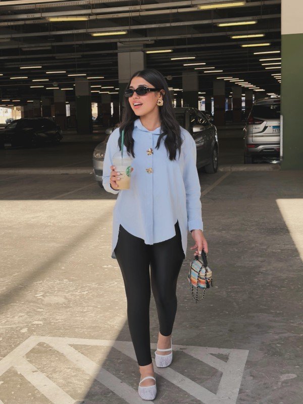 Black leather leggings paired with a white button-down shirt and flats for a classic everyday outfit.