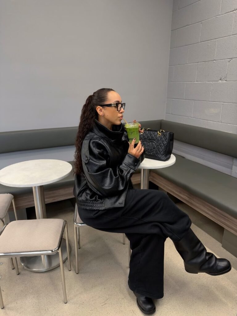 Woman styling black sweatpants with ankle boots and a fitted top for a chic casual fall outfit.