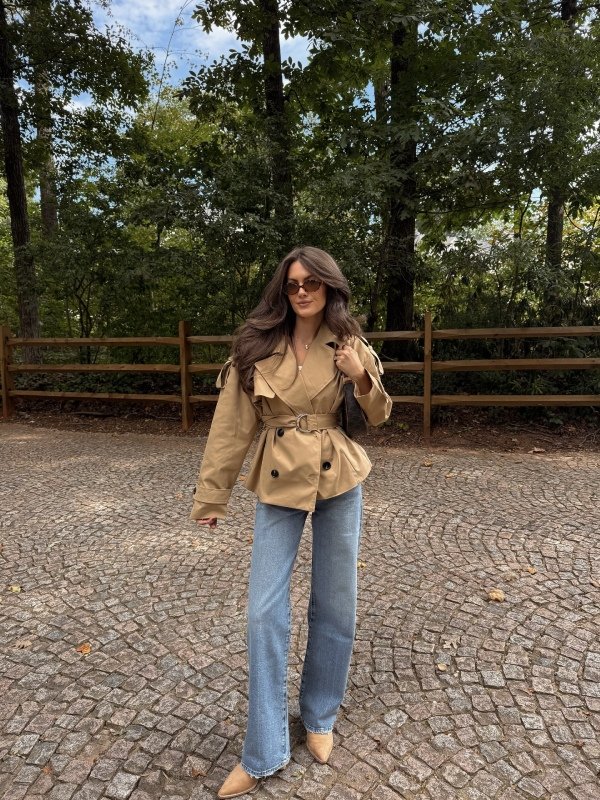 Modern cropped trench coat styled with high-waisted jeans, a fitted top and casual boots